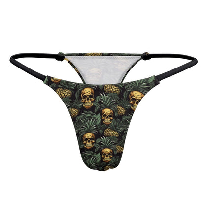 A thong featuring an all-over print of yellow human skulls nested inside green pineapple leaves against a dark background.