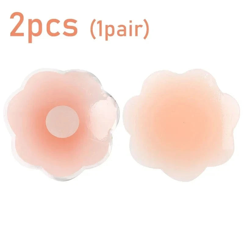 A pair of light skin-toned, flower-shaped silicone nipple covers are displayed against a white background.