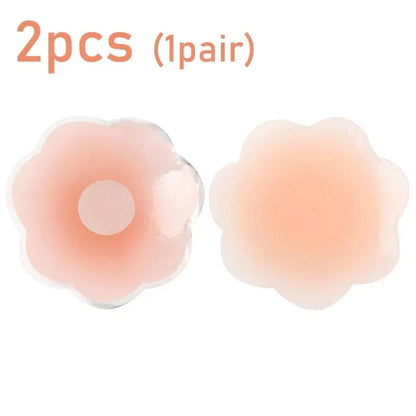 A pair of light skin-toned, flower-shaped silicone nipple covers are displayed against a white background.