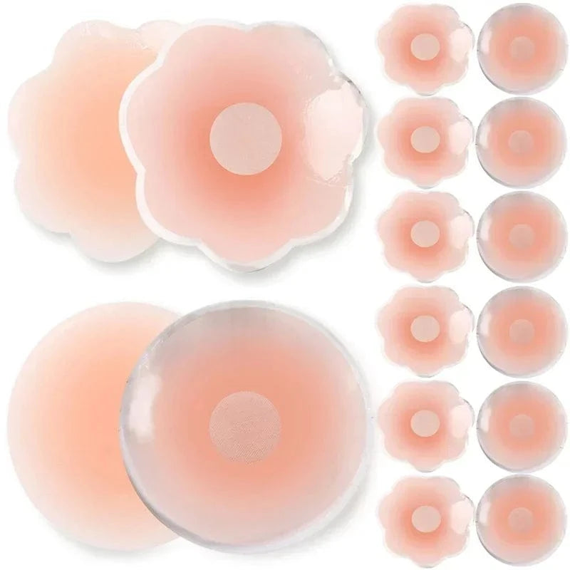 A collection of pale pink silicone nipple covers in various round and flower-shaped designs, laid out against a white background.