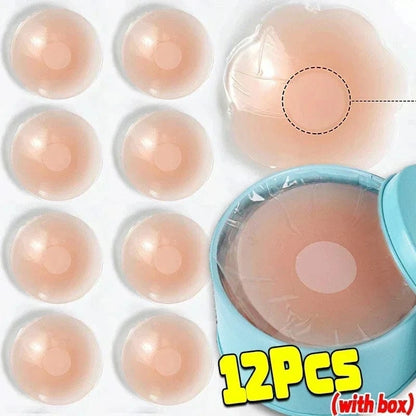 Twelve circular, beige silicone nipple covers are displayed against a white background, including one shown in a blue storage tin.