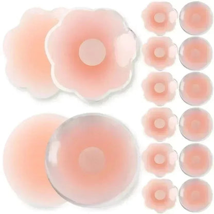 A collection of round and flower-shaped adhesive nipple covers in a soft pink, translucent tone arranged against a plain white background.