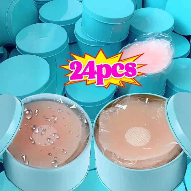 Round light blue storage tins are piled together, with two open containers in the foreground revealing beige, circular adhesive silicone nipple covers protected by transparent plastic film.