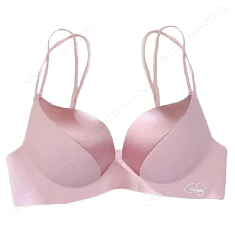 A light pink padded brassiere with thin, double-strap shoulder straps and a smooth, seamless finish against a white background.