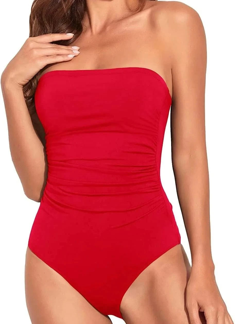 A strapless, one-piece swimsuit in a bright red color featuring ruched detailing along the torso.
