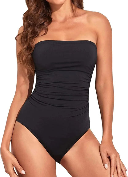 A strapless one-piece swimsuit in solid black with ruched detailing along the sides of the torso.