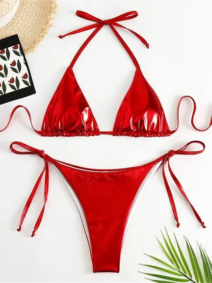 A red metallic bikini set features a triangle bikini top and matching side-tie bikini bottoms laid flat against a white background.