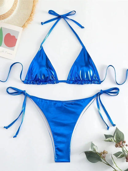 A metallic blue string bikini set with triangular cups and tie-side bottoms laid flat against a white surface.