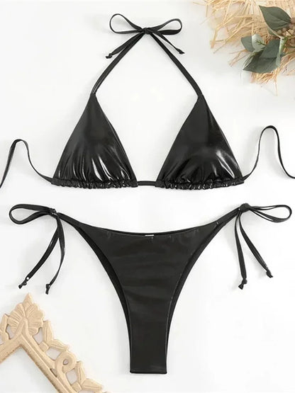 A black two-piece bikini set featuring a triangle halter top with thin tie straps and matching high-cut bikini bottoms with side ties, laid flat against a white background.