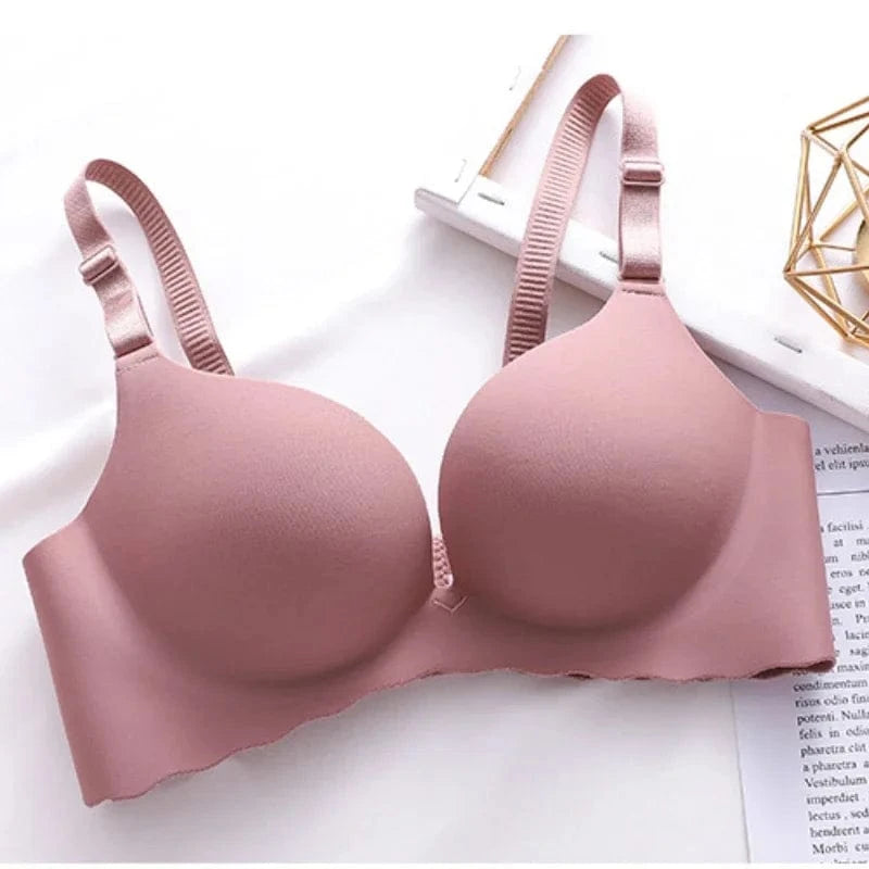 A mauve pink seamless push-up bra with adjustable straps and a scalloped bottom edge displayed against a white background.
