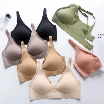 A flat lay of seven seamless, wire-free bras arranged in a fan shape on a white surface, featuring a color palette of black, olive green, beige, tan, and light pink.