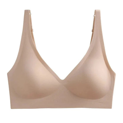 A beige wireless bra featuring a deep V-neckline, smooth seamless construction, and adjustable shoulder straps against a plain white background.