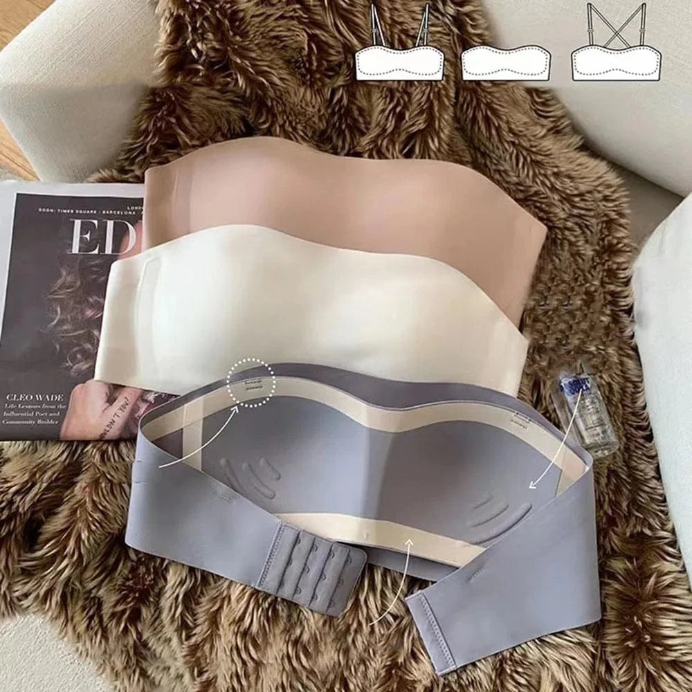 Three strapless bras in nude, white, and grey are displayed on a furry rug next to a book and a small bottle, with an inset diagram showing three different strap configurations.