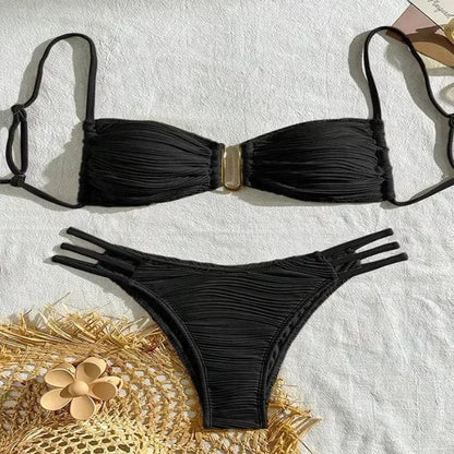 A black two-piece bikini set featuring a textured, ruched strapless top with a central gold-tone metal accent and matching bottoms with triple-strap side cutouts.