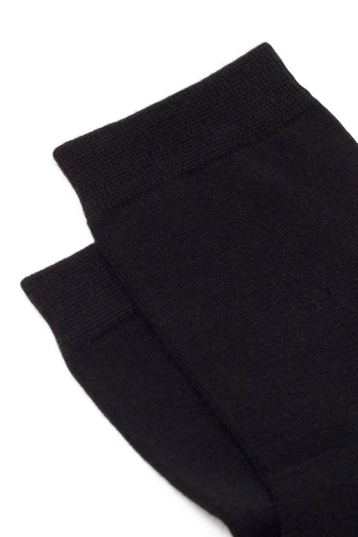 A pair of folded black socks on a white background.