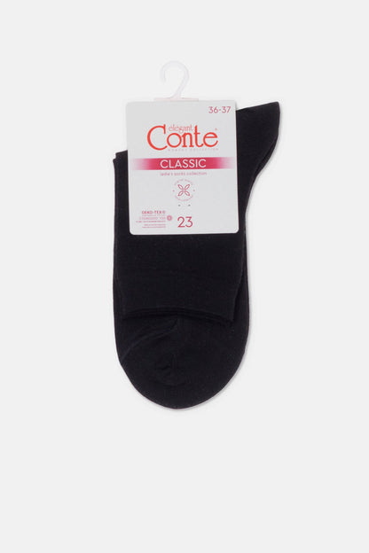 A pair of black ankle-length socks folded over a white cardboard retail tag with a hanger hook.
