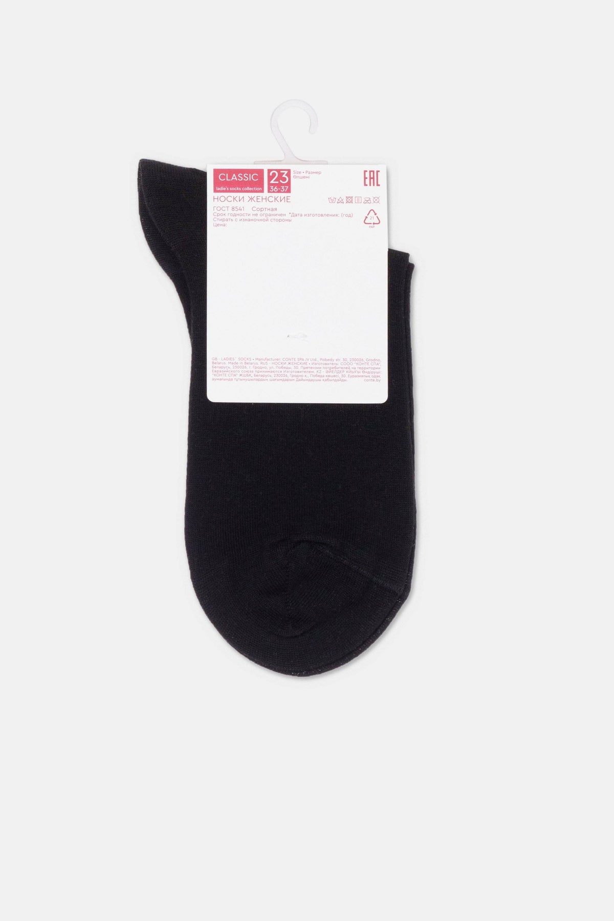 A pair of plain black ankle socks are displayed flat against a plain light gray background with a white cardboard product tag attached to the top.