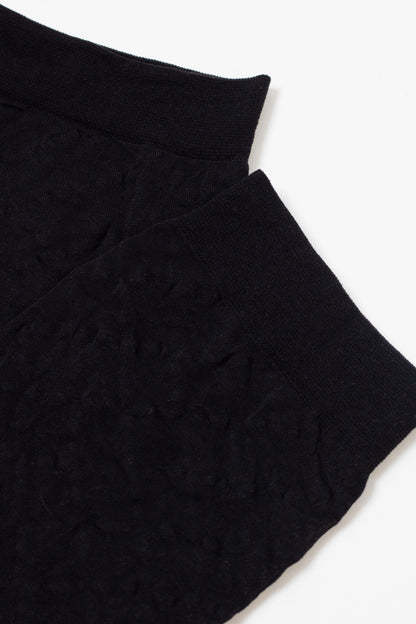 A pair of black, textured ankle socks shown from a top-down perspective.