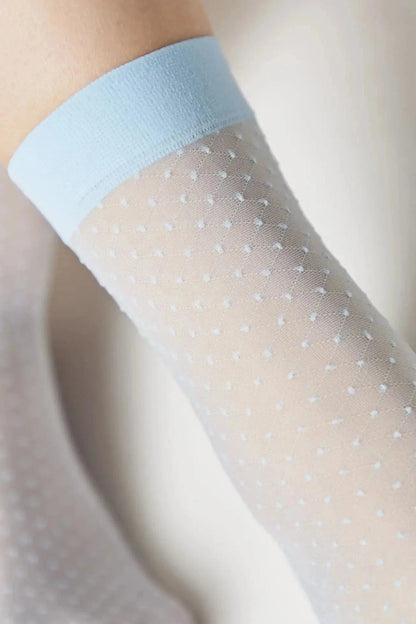 A sheer white knee-high sock featuring a subtle diamond-patterned dot texture and a solid light blue ribbed cuff.