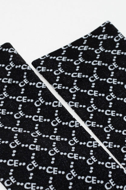 Two black fabric panels with a repeating white logo pattern featuring the letters CE separated by dots are displayed against a plain white background.