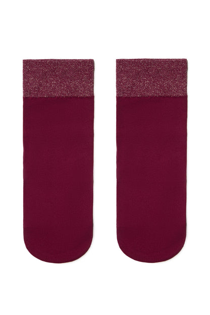 Two ankle socks in a deep burgundy shade, featuring a contrasting shimmery, glittery textured band at the cuff.