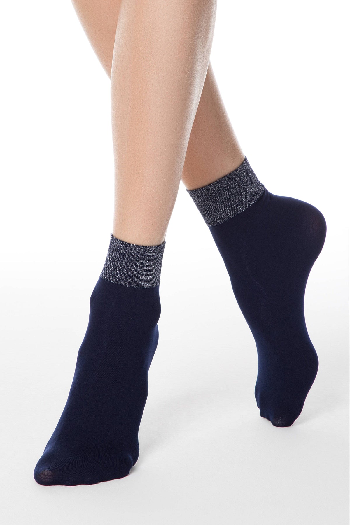 A pair of sheer navy blue ankle socks with shimmering metallic grey cuffs worn on a person's feet against a plain white background.