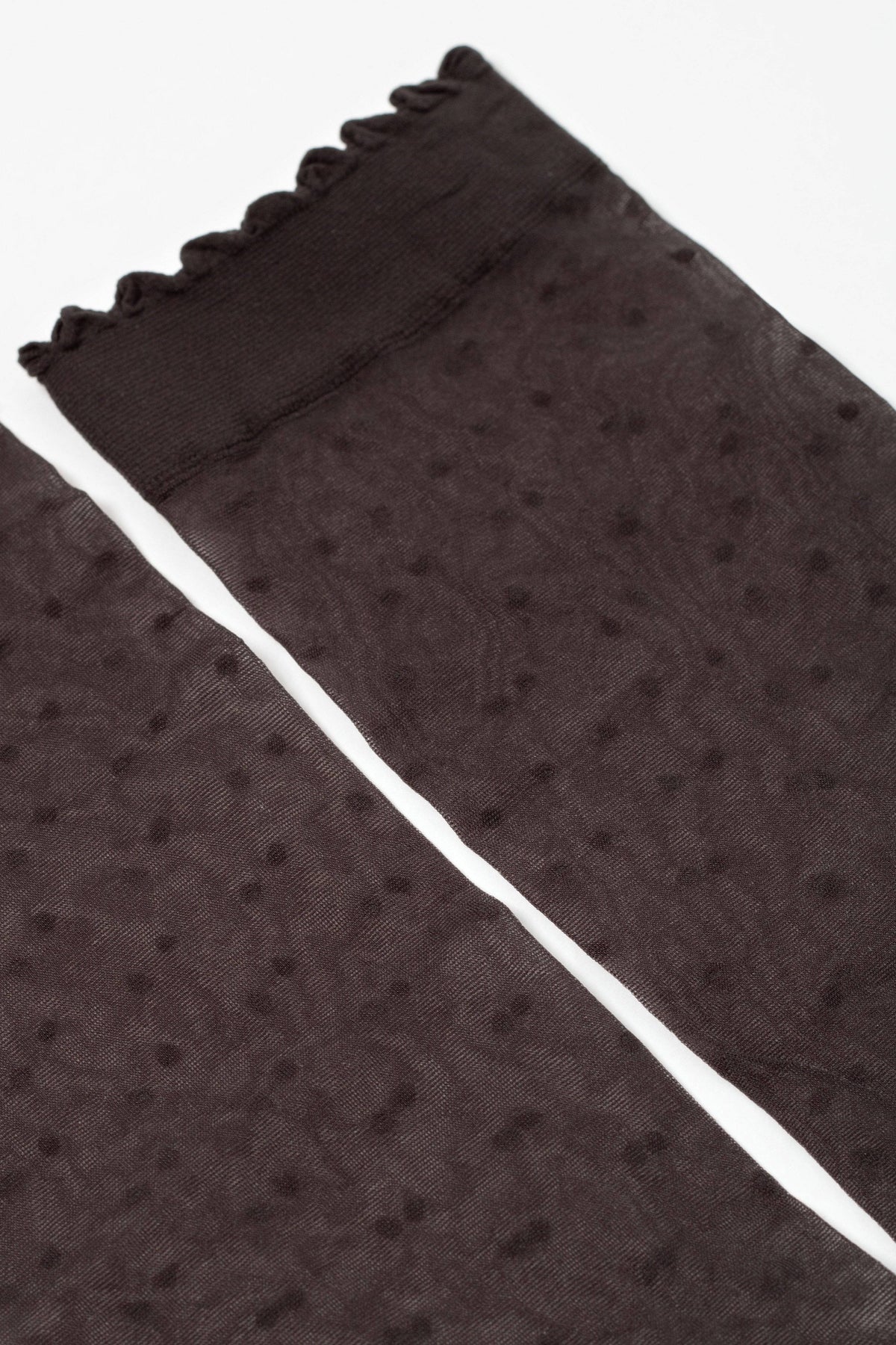 A pair of sheer, dark brown stockings with a delicate polka dot pattern and a ruffled, scalloped top edge.