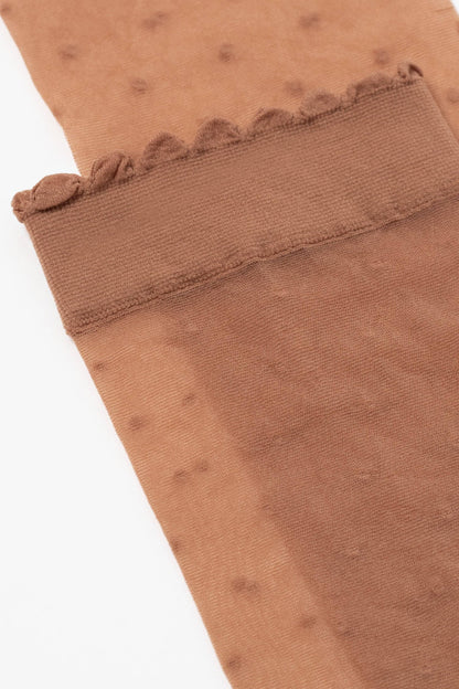 A close-up of a pair of brown sheer pantyhose featuring a delicate scalloped edge at the cuff and a subtle polka dot pattern.
