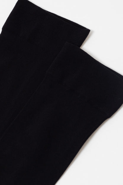 A pair of plain black socks shown against a solid white background.
