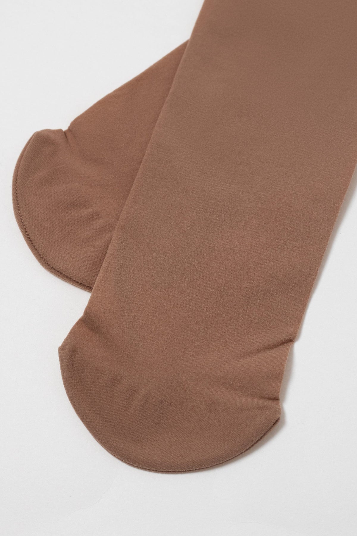 A pair of brown tights shown close up against a plain white background, focusing on the reinforced rounded toe and foot sections.