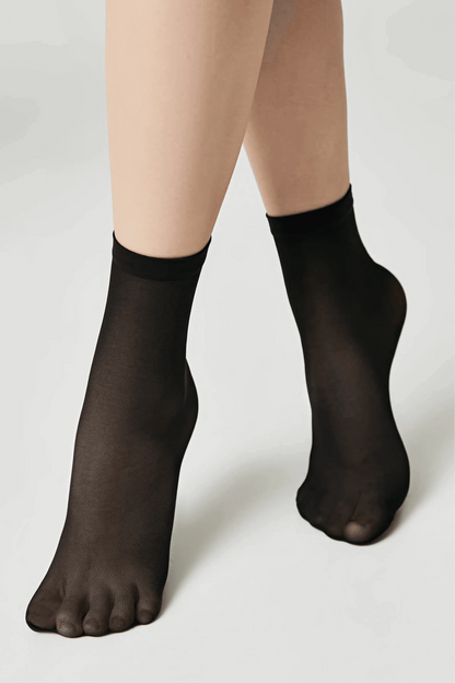 A pair of sheer black ankle socks worn on feet against a plain white background.