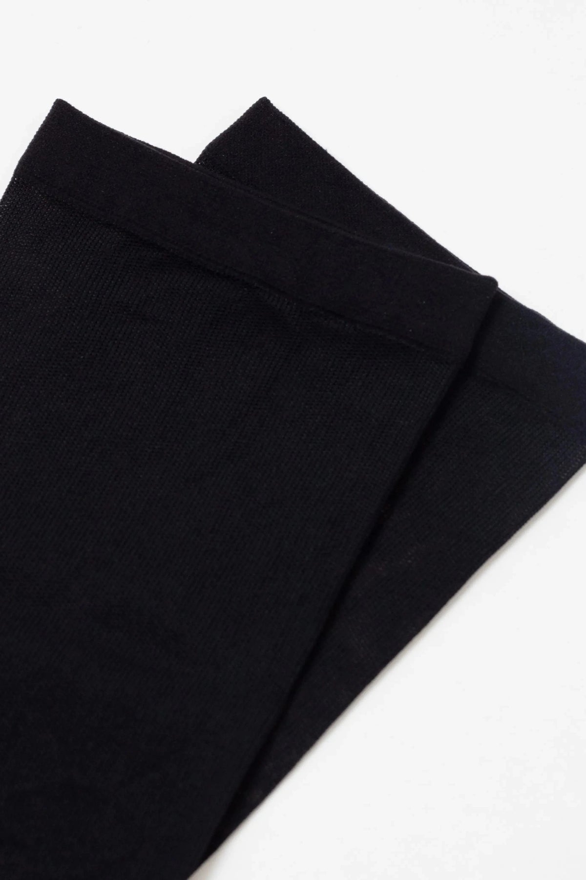 Two plain black socks displayed against a white background.