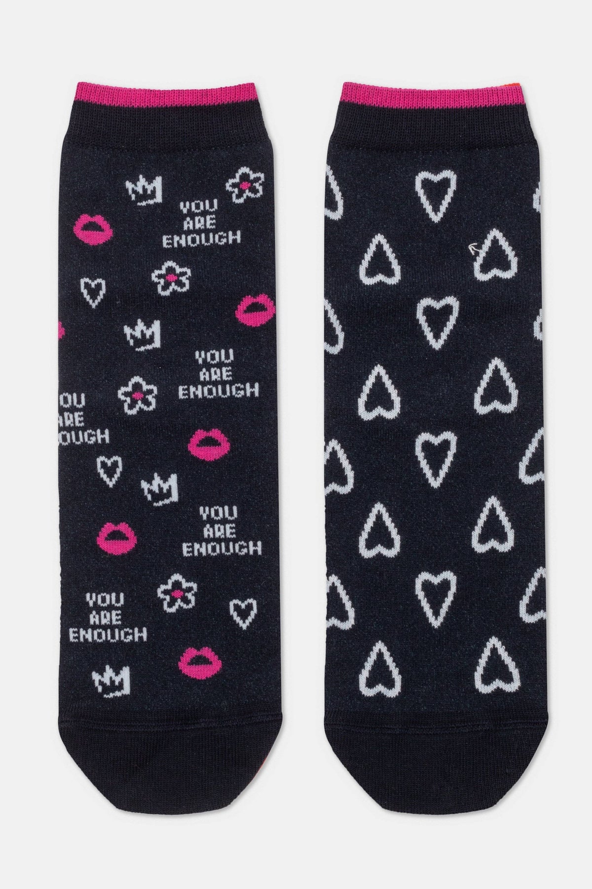 A pair of black ankle socks featuring a print of white hearts, pink lips, crowns, flowers, and the phrase "YOU ARE ENOUGH" in white text, with pink cuffs at the top.