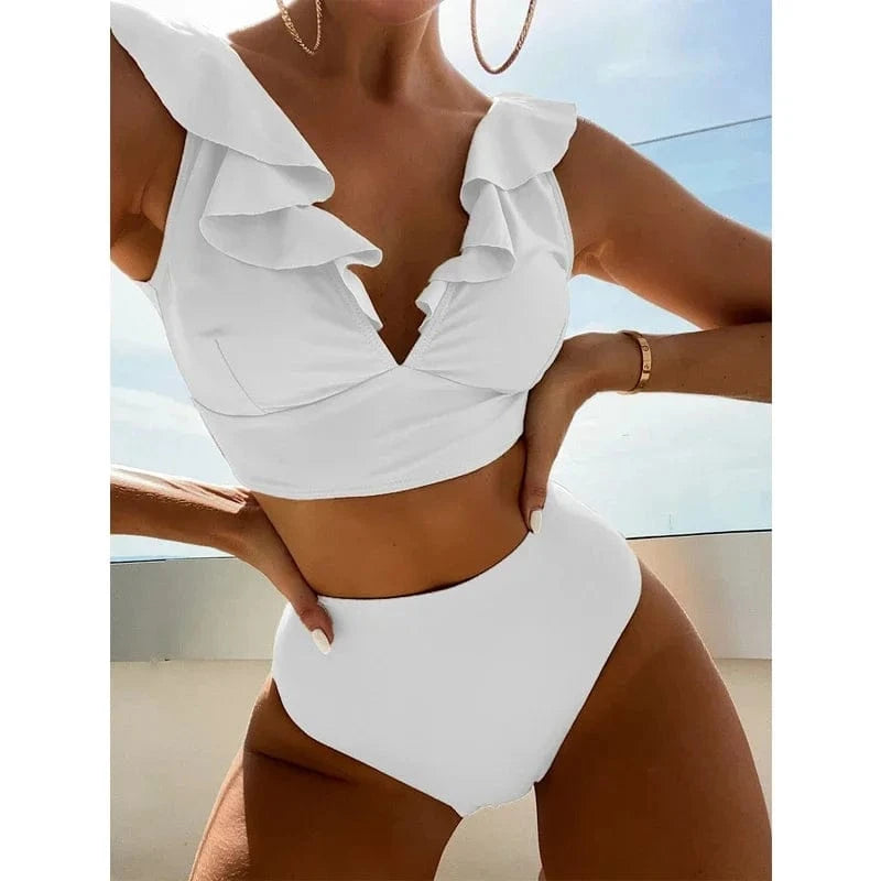 A woman models a plain white high-waisted bikini set featuring a ruffled neckline on the top piece.
