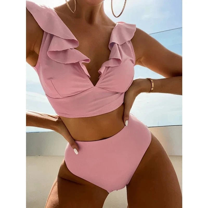 A light pink two-piece bikini featuring a cropped top with ruffled shoulder straps and a high-waisted bottom.
