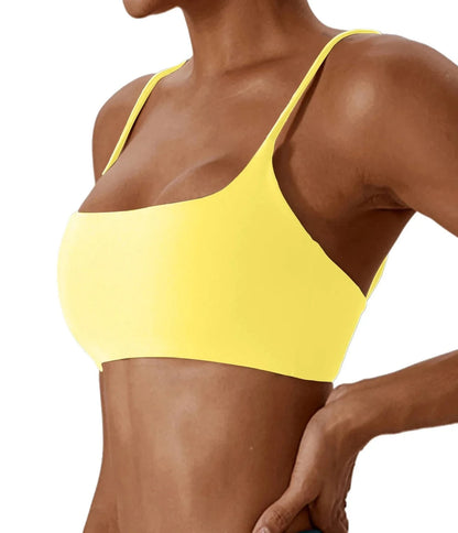 A bright yellow bikini top featuring a scoop neckline and thin shoulder straps, worn by a person.