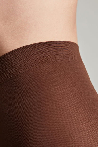 Solid brown tights with a ribbed elastic waistband worn against bare skin.