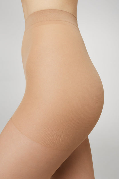 A close-up side view of skin-toned hosiery worn on the lower torso and upper thighs against a plain grey background.