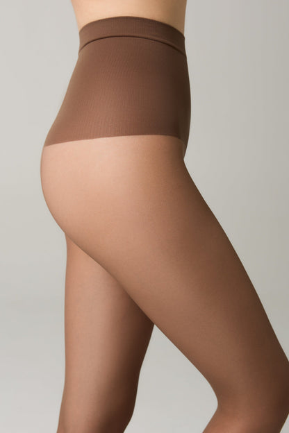 A close-up side profile view of a person wearing sheer tan tights with a seamless high-waist band on a plain light grey background.