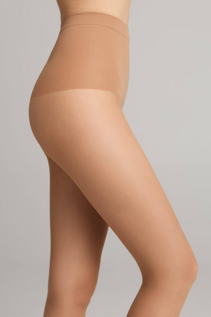 A person wearing nude-colored high-waisted sheer tights from the side profile against a solid light gray background.