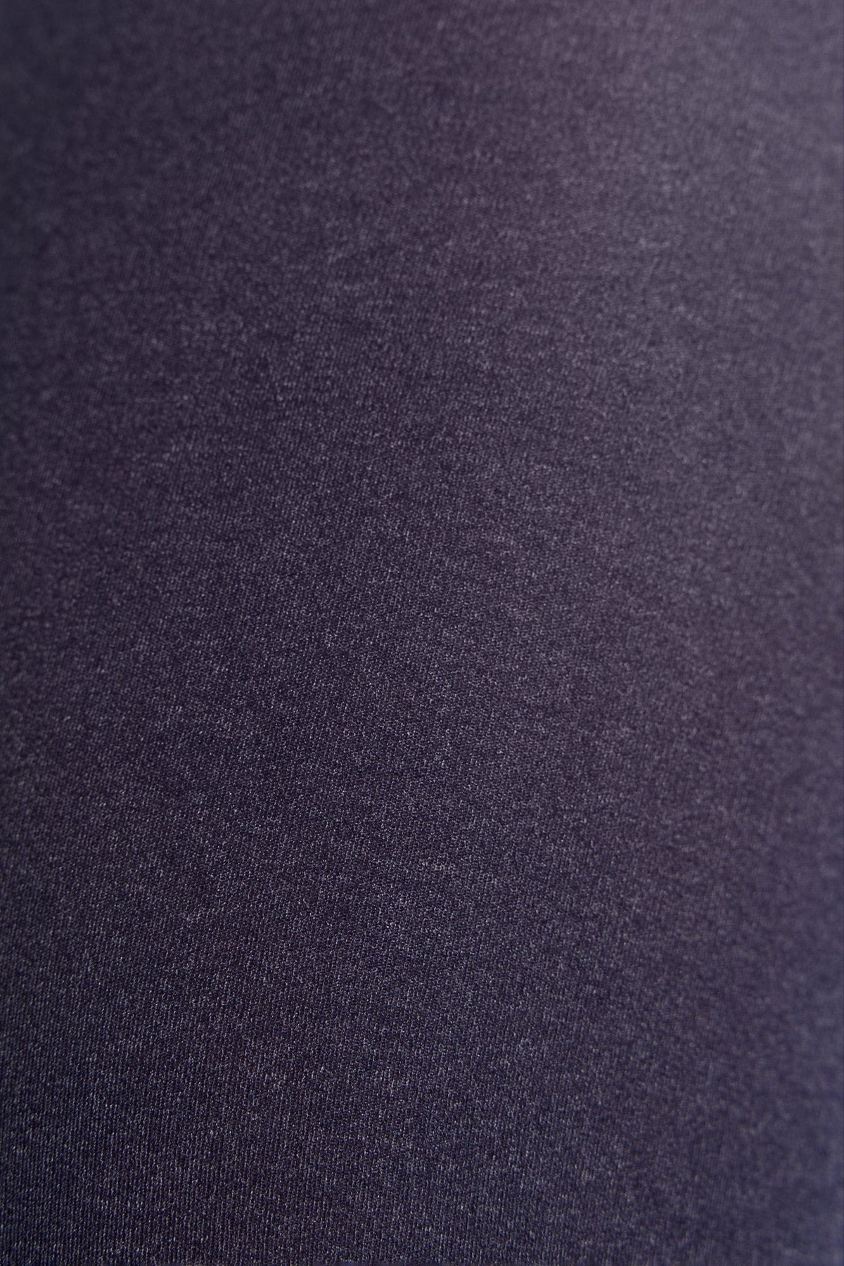 A close-up view of solid dark purple fabric with a fine, smooth knit texture.