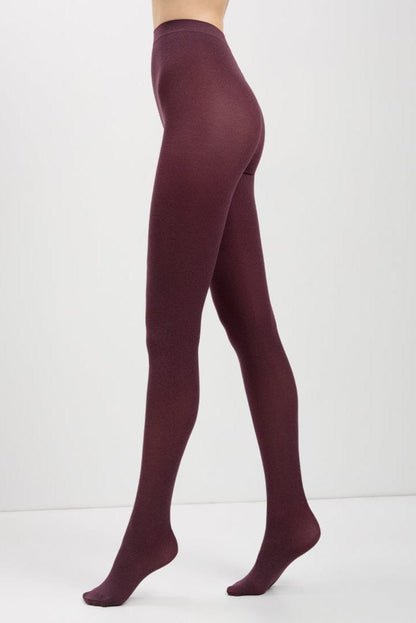 Opaque burgundy tights worn by a person shown from the side against a plain white background.