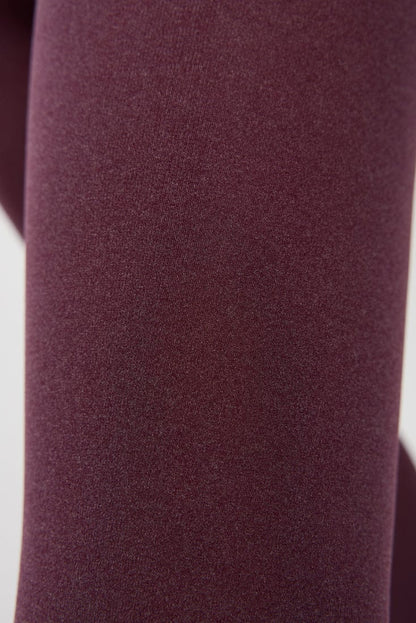 A close-up view of maroon-colored, smooth fabric texture.