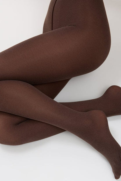 Opaque chocolate brown tights worn on a pair of crossed legs against a plain white background.