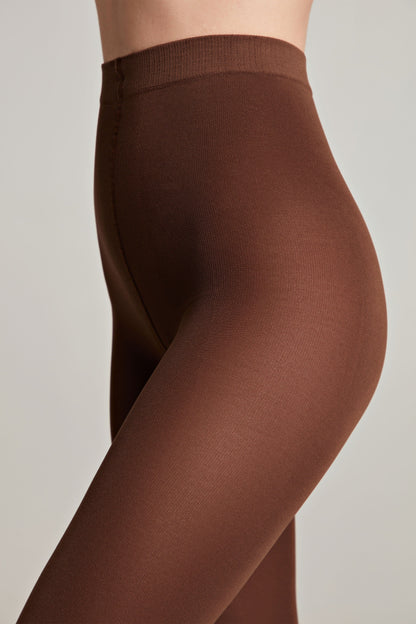 Brown tights worn by a person, shown from the side against a neutral background.