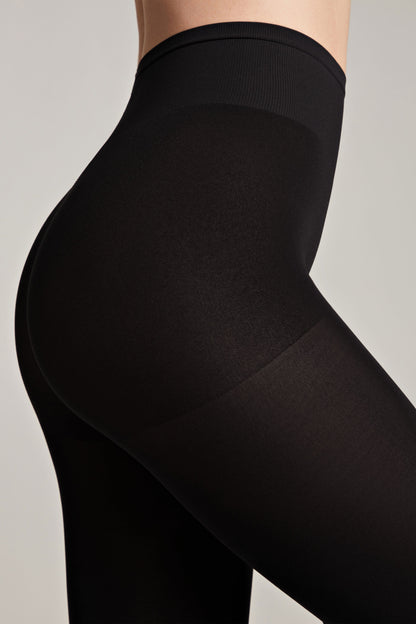 Black opaque high-waisted shaping tights worn by a person, featuring a reinforced control top panel and smooth seamless texture.