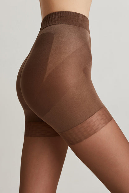 A close-up side view of brown high-waisted shaping shorts worn on a person, featuring reinforced paneling on the hips and a sheer finish on the legs.