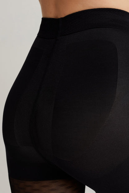 Black shaping tights feature a high waistband and reinforced panels designed to provide support around the hips and glutes.