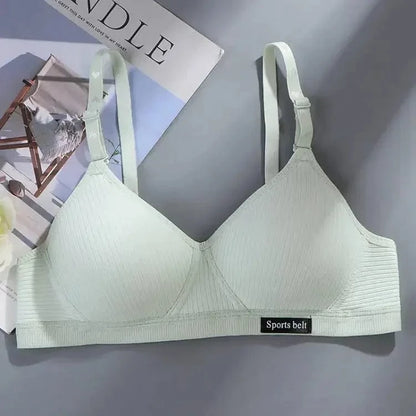 A light mint green ribbed wireless bralette with adjustable straps and a small black patch labeled Sports belt at the bottom band.