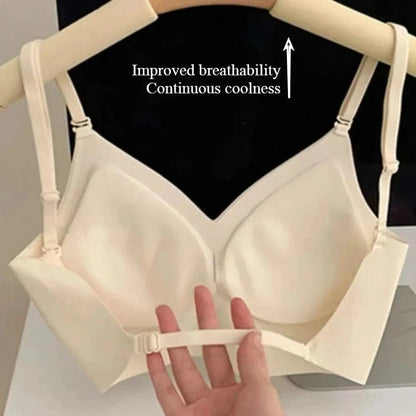 A beige wireless bra hangs on a hanger with a hand pulling on its adjustable bottom strap, featuring molded cups and an arrow graphic pointing upward with the text Improved breathability Continuous coolness.